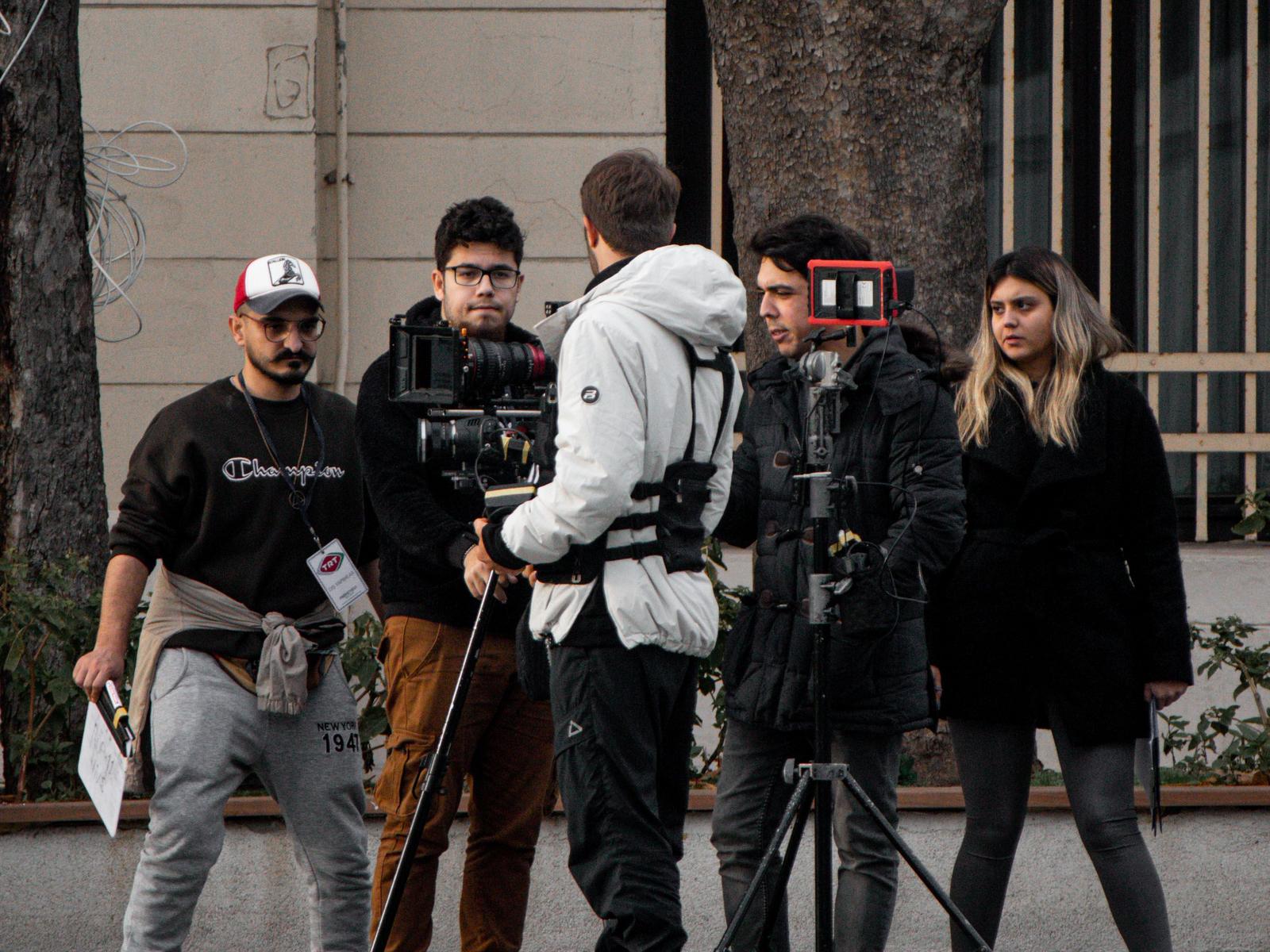 A young film crew at work on location, shooting with a professional cinema camera